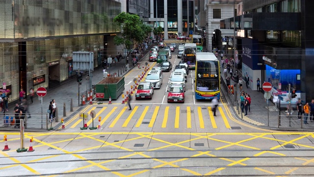 4K时间推移:车辆和行人在香港市中心商业区的交通场景视频素材