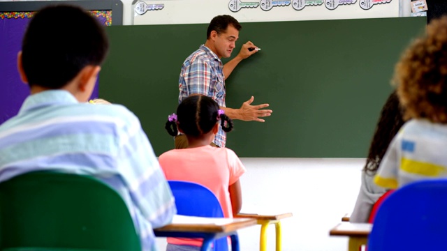 白人男老师在教室的白板上教学生的侧视图视频素材