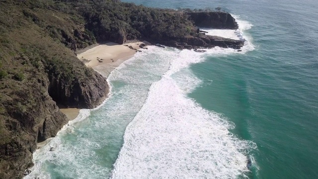 空中向前:白色海浪撞击海岸的草，岩石山，努沙，澳大利亚视频素材