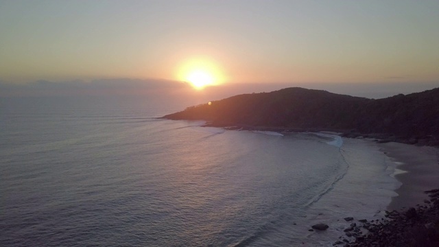 空中向前:小山丘上的海浪和地平线上的日落，努萨，澳大利亚视频素材