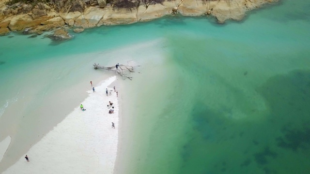 空中右转:人群在浅蓝色的海洋中放松，在桑迪岛，圣灵群岛，澳大利亚视频素材