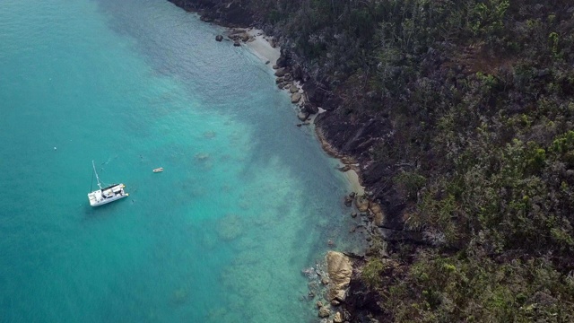 空中向前:树木覆盖的山在充满活力的蓝色海洋海岸，圣灵群岛，澳大利亚视频素材