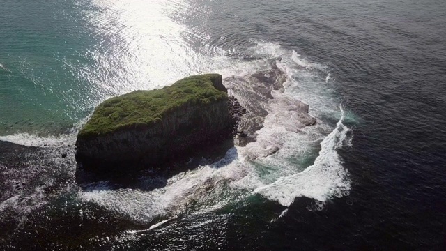 右图:阳光照耀下的长满草的岛屿，深蓝色的海浪，澳大利亚卧龙岗视频素材