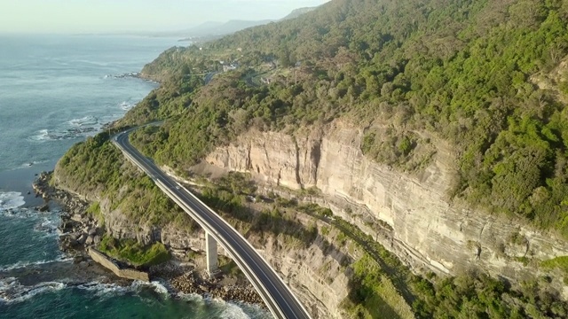 空中向前:澳大利亚卧龙岗，落基山脉底部，海洋边缘的桥视频素材