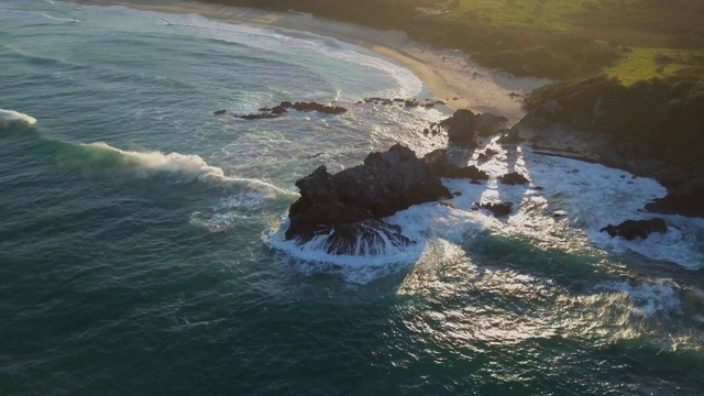 空中向后:海浪冲击巨大的骆驼岩在美丽的海滩，贝马居，澳大利亚视频素材