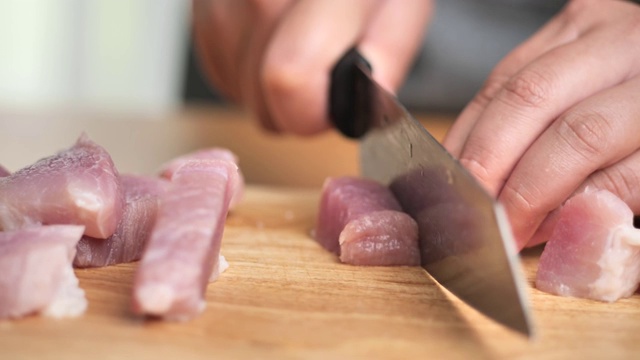 男孩在砧板上切猪肉，生活理念。视频素材