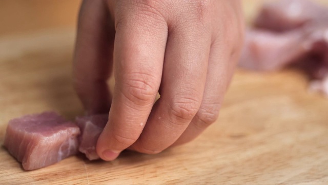 男孩在砧板上切猪肉，生活理念。视频素材