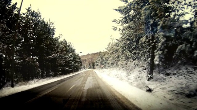 汽车行驶在一个冬天的日出与雪在霜冻的道路上视频素材