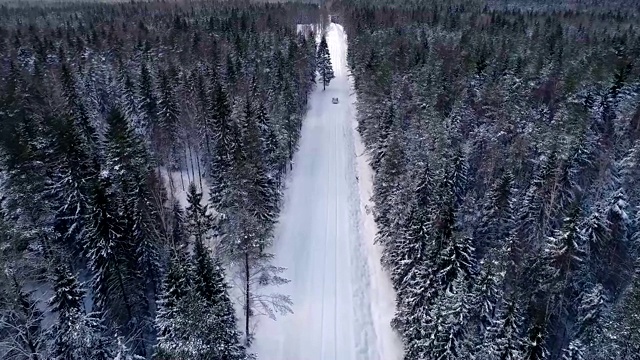 一辆汽车在爱沙尼亚雪地里倒车的鸟瞰图视频素材