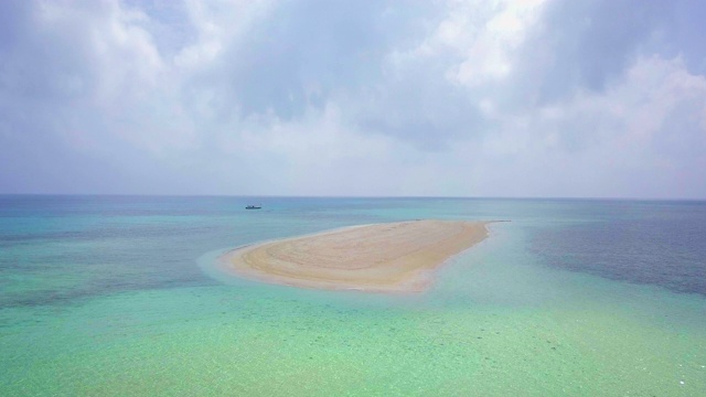 空中倾斜:澳大利亚大堡礁珊瑚礁间美丽的蓝色海洋中的小沙岛视频素材