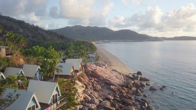 空中向前:美丽的热带海岸上的平房和郁郁葱葱的绿色山脉，磁岛，澳大利亚视频素材