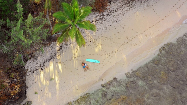 天线:一对夫妇躺在夏威夷瓦胡岛的热带海滩上视频素材