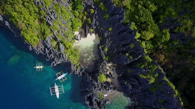 航拍:菲律宾巴拉望蓝海附近陡峭岩石中的隐藏海滩视频素材