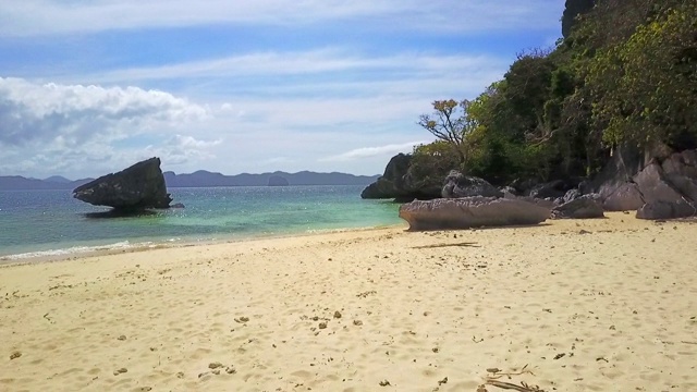 航拍:波光粼粼的海洋、大岩石和菲律宾巴拉望的沙滩视频素材