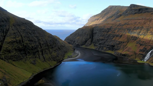 高空山谷与湖之间的大型岩石面，湖在前景，斯特雷莫伊岛，法罗群岛视频素材