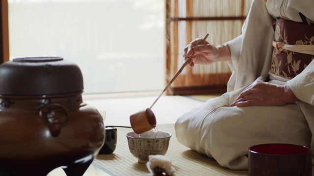 日本礼仪主持人往茶碗里量水视频素材