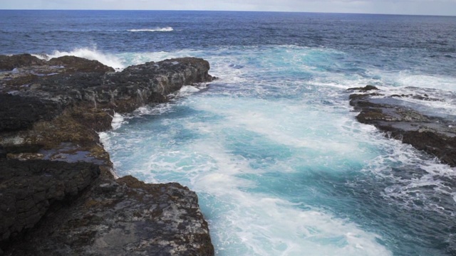 慢镜头:海浪冲击着夏威夷海域的火山岩，夏威夷考艾岛视频素材