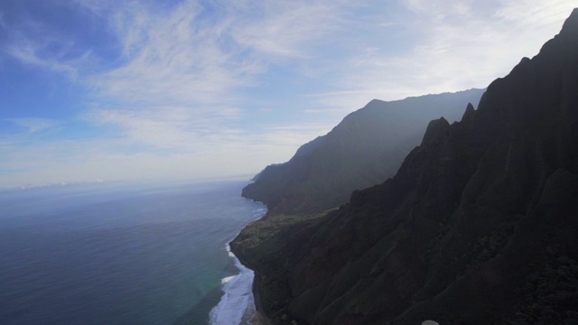 泛光:黑暗的夏威夷山在海洋，蓝天和太阳之上，考艾岛，夏威夷视频素材