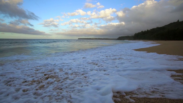 慢镜头:小海浪拍打在夏威夷考艾岛的沙滩上视频素材