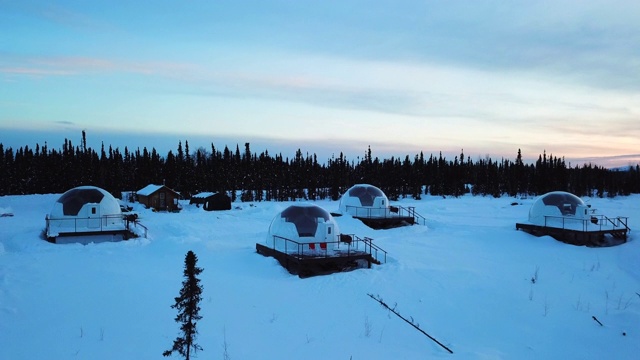 空中右/上升:阿拉斯加费尔班克斯白雪皑皑平原上森林旁的冰屋视频素材