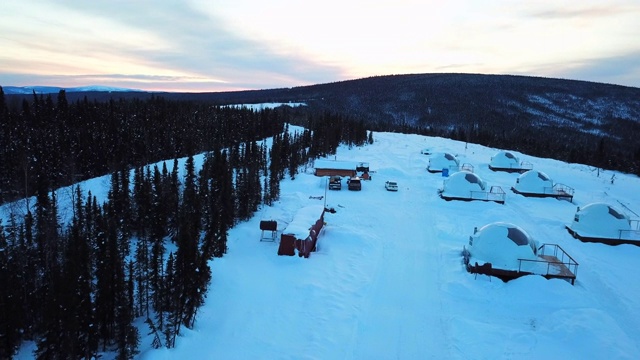 空中下降/右:阿拉斯加费尔班克斯雪原上森林旁的冰屋视频素材