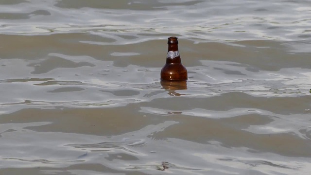 一个瓶子漂浮在水波中，一个瓶子在水波中游动，视频素材