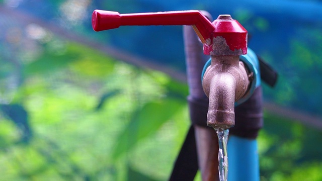 水从旧的红色水龙头流出。节约能源，节约水资源。视频素材