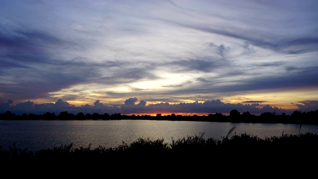 时间流逝夕阳后面移动的云。给沼泽带来了美丽的金色光芒。视频素材