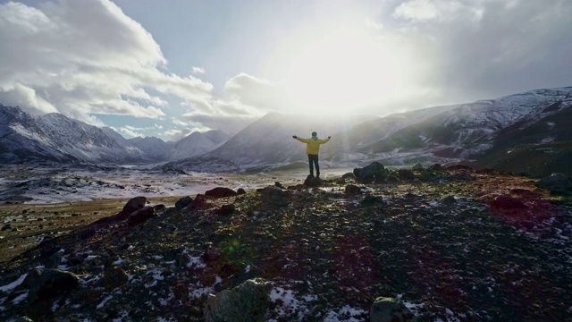 一名男性登山者在雪峰上举起手拿冰锥视频素材