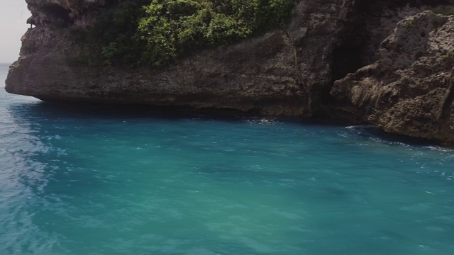 绿松石海水和岩石悬崖空中景观。美丽的风景，清澈的大海和悬崖山在天际线的背景。蓝色海水和岩石岛无人机视图视频素材