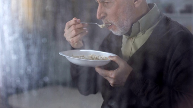 女性用手把盘子里的无味粥送给老人，敬老院饮食视频素材