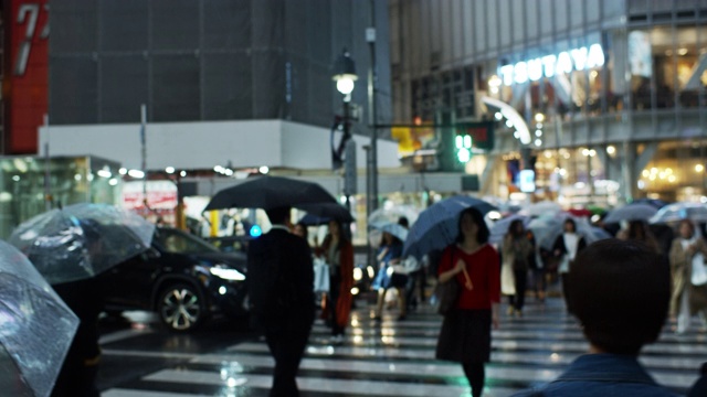 手持式拍摄下雨夜涉谷十字路口的行人视频素材