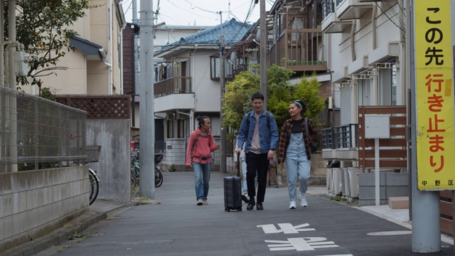 年轻的背包客一起走在东京住宅街上视频素材