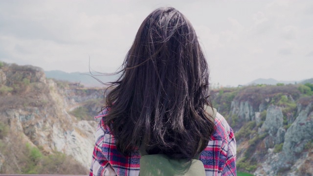 徒步旅行者亚洲背包女在山顶，女性享受她的假期徒步冒险感觉自由。生活方式女性旅行和放松的自由时间概念。视频素材