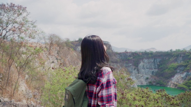 慢动作-徒步旅行者亚洲背包女步行到山顶，女性享受她的假期在徒步冒险感觉自由。生活方式女性旅行和放松的自由时间概念。视频素材