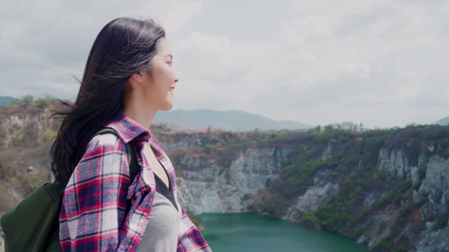 慢动作-徒步旅行者亚洲背包女步行到山顶，女性享受她的假期在徒步冒险感觉自由。生活方式女性旅行和放松的自由时间概念。视频素材