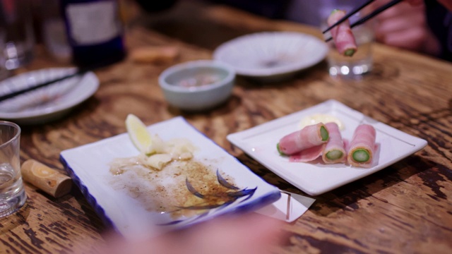 朋友们吃传统日本居酒屋食物的特写视频素材