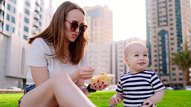 夏天，在公园里，妈妈用午餐盒喂孩子视频素材