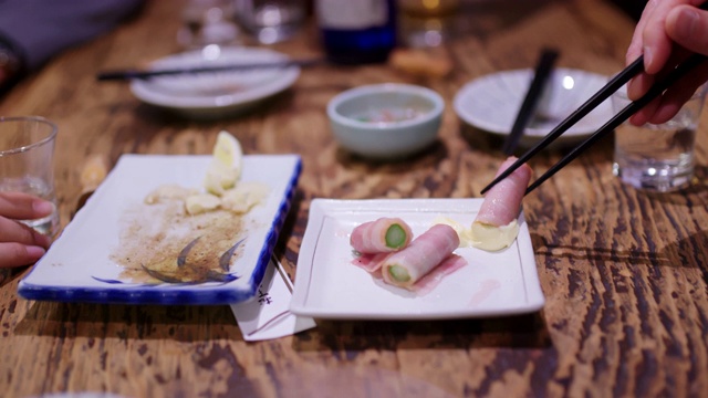 朋友们吃传统日本居酒屋食物的特写视频素材