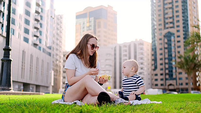 夏天，在公园里，妈妈用午餐盒喂孩子视频素材