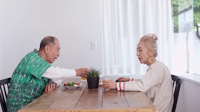 一对老年夫妇在家里一起享受早餐的广角镜头视频素材