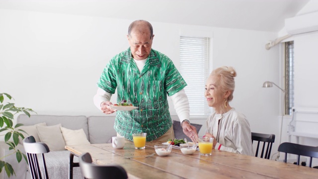 中景一位老人在家里为妻子提供早餐视频素材