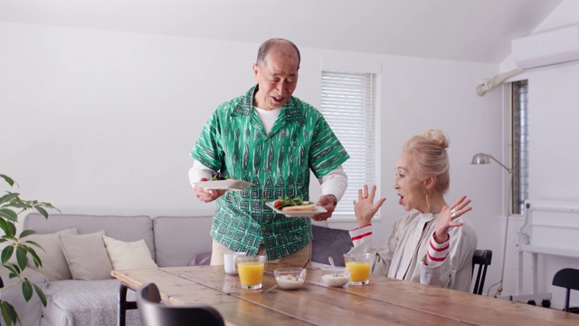 中景一位老人在家里为妻子提供早餐视频素材