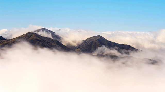 在阳光明媚的日子里，白云在高山山谷中快速移动视频素材