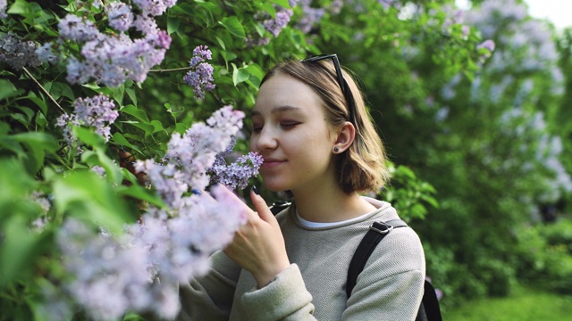 女孩在春天的公园闻花视频素材