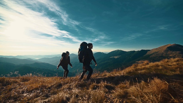 在阳光明媚的背景下，这对夫妇在山上散步。慢动作视频素材