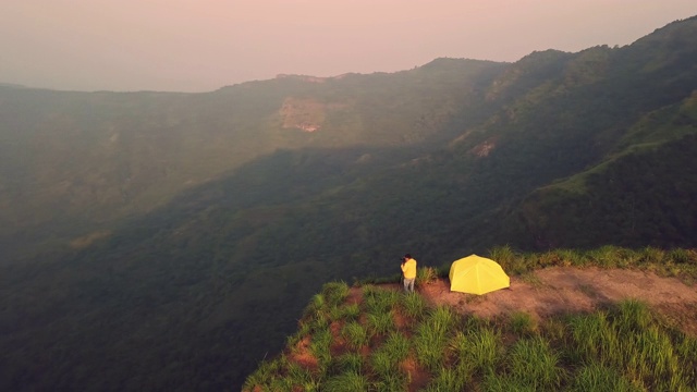 4k分辨率鸟瞰图的旅游摄影师露营和帐篷的悬崖和美丽的山，在Phu Tubberk泰国旅游冒险概念视频素材