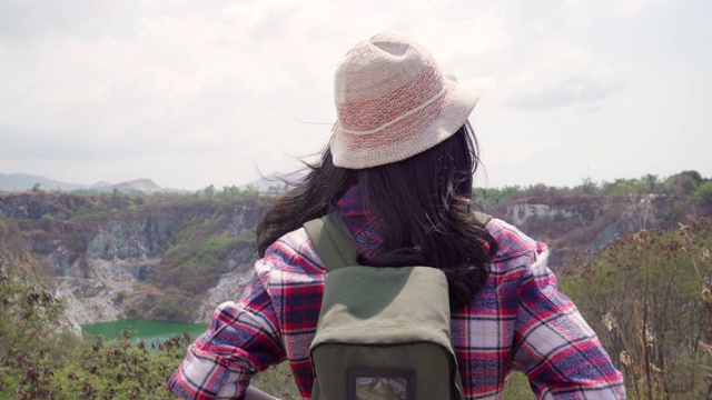 徒步旅行者亚洲背包女步行到山顶，女性享受她的假期在徒步冒险感觉自由。生活方式女性旅行和放松的自由时间概念。视频素材