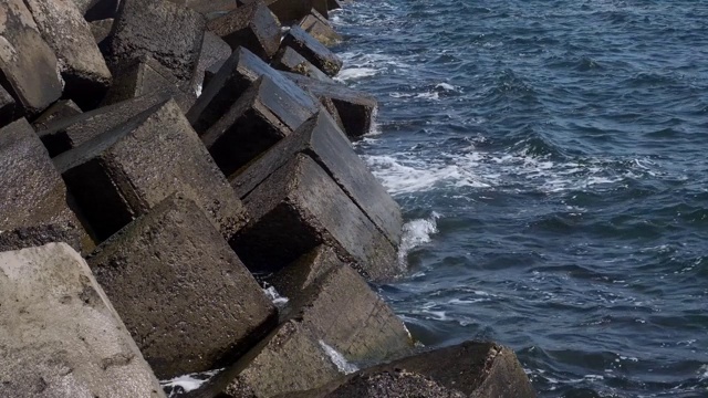 沿海混凝土防护结构破坏。板块之间的大而深的裂缝保护海岸免受海浪冲击的侵蚀。巨大的混凝土与钢筋保护海岸，特写，全高清- 60fps视频素材