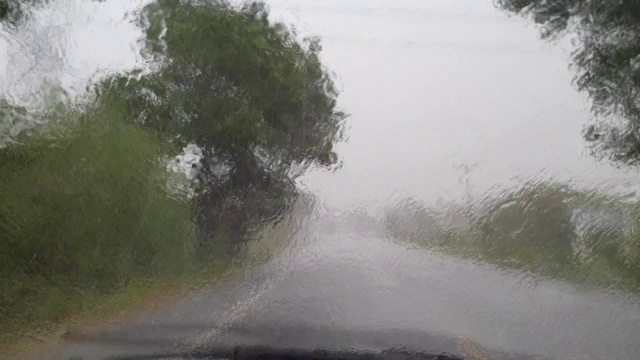 在大雨中驾驶，透过挡风玻璃观看视频素材